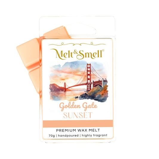Eine Packung Melt & Smell Premium Wax Melt mit der Aufschrift „Golden Gate SUNSET“. Die Verpackung zeigt eine idyllische Aquarellszene der Golden Gate Bridge bei Sonnenuntergang, mit der roten Brücke, die eine Bucht überspannt, umgeben von Hügeln und mit einem orangefarbenen und lila Himmel im Hintergrund. Der Duftwachs selbst, das oben links aus der Verpackung herausragt, ist pfirsichfarben. 